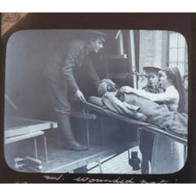 Load image into Gallery viewer, Original Glass slide showing a wounded Sikh soldier taken to an ambulance on a stretcher by an English nurse. WWI c1914 - ramblingsofasikh
